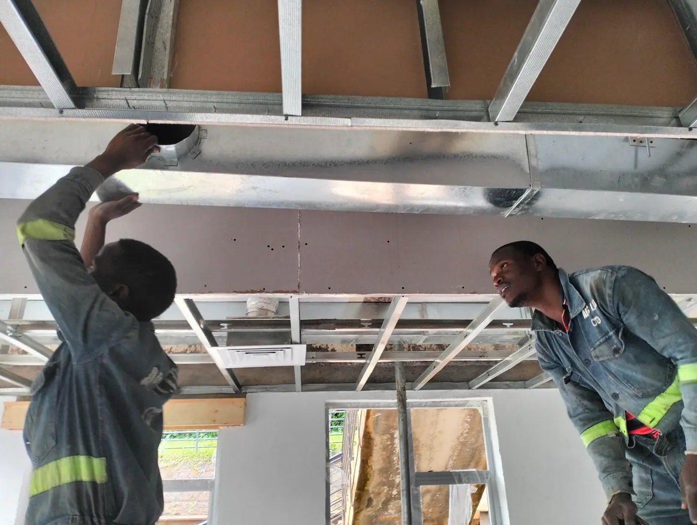 M-Cool technicians installing HVAC ceiling ducting